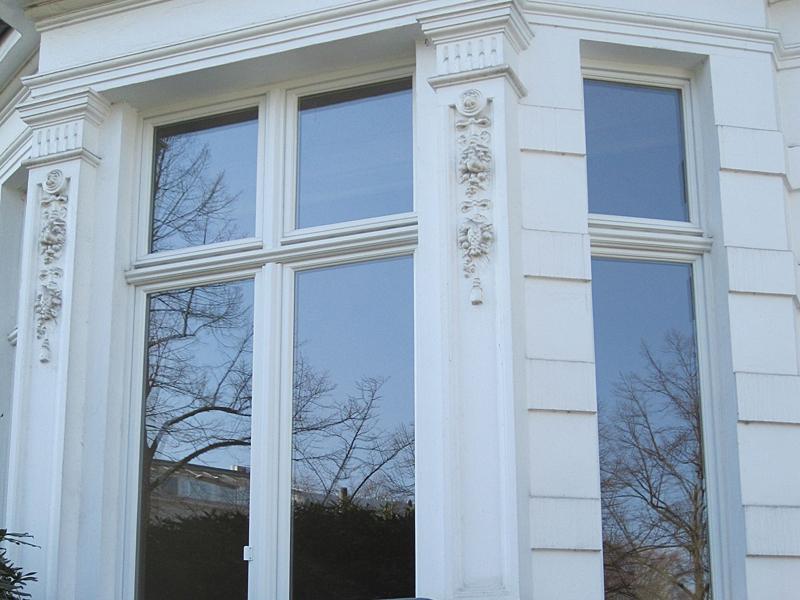 Weiße Außenfassade eines Hauses mit großen Kastenfenstern