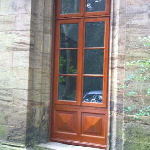 Braune Holztür mit Sprossenfenstern eingemauert über Treppenstufen