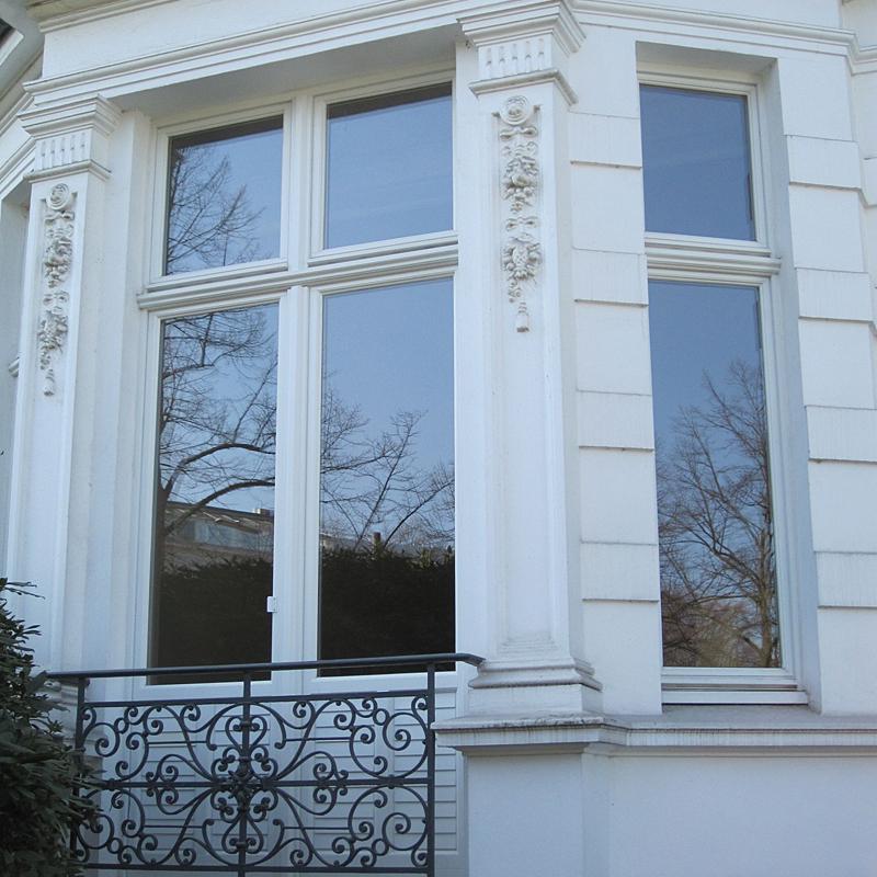 Weiße Außenfassade eines Hauses mit großen Kastenfenstern