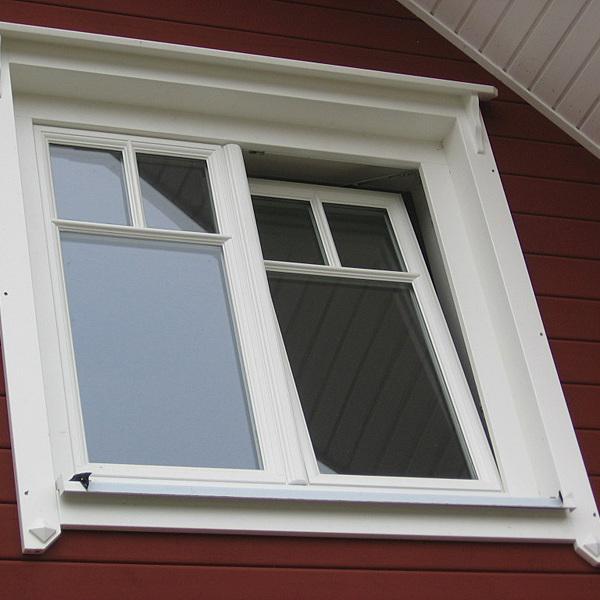 Zwei Kastenfenster mit weißem Rahmen in roter Hauswand