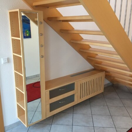 Holzgarderobe und Holztreppe im Eingangsbereich eines Hauses