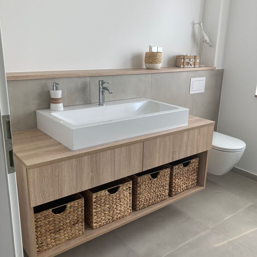 Waschbeckenunterschrank aus Holz mit vier Körben unter weißem Waschbecken