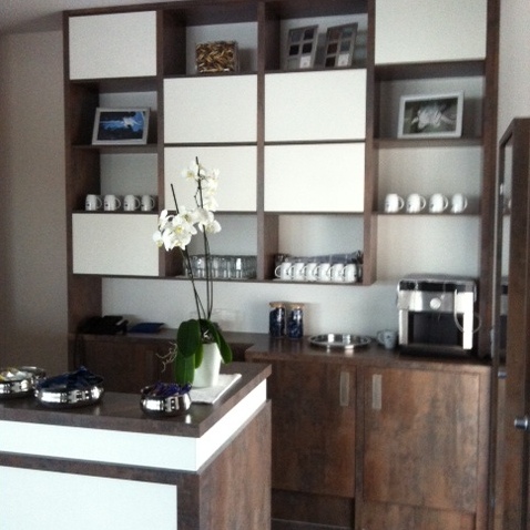 Küchenfront aus dunklem Holz mit weißen Türen vor Kochinsel