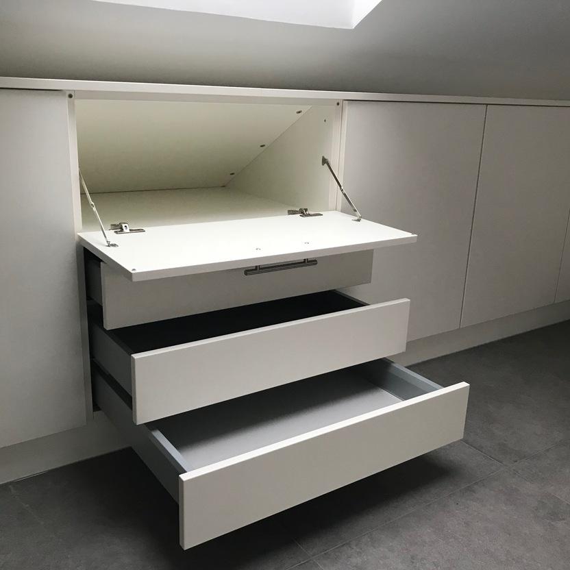 Maßgefertigter Schrank mit zwei offenen Schubladen und einer offenen Schranktür in einem modernen Innenausbau.