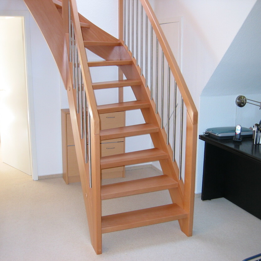 Treppenaufgang aus Holz neben Schreibtisch in Wohnraum