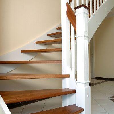 Holztreppe mit weißen Wangen und dunklen Massivholzstufen in klassischer Ausführung, passend zu einem hellen Wohnbereich.