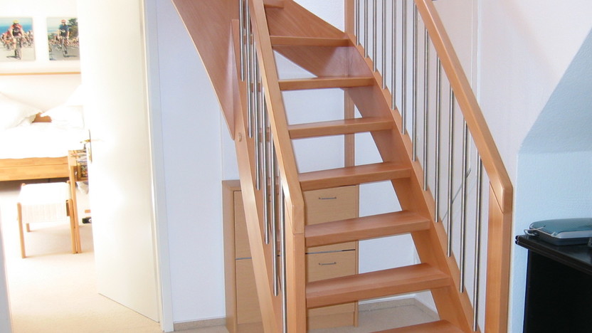 Treppenaufgang aus Holz neben Schreibtisch in Wohnraum
