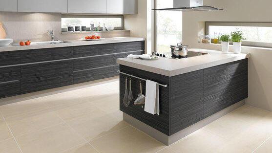 Individuelle Küchenmöbel nach Maß Kochinsel mit grauen Fronten und weißer Arbeitsplatte vor passender Küchenzeile