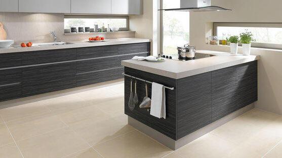 Individuelle Küchenmöbel nach Maß Kochinsel mit grauen Fronten und weißer Arbeitsplatte vor passender Küchenzeile