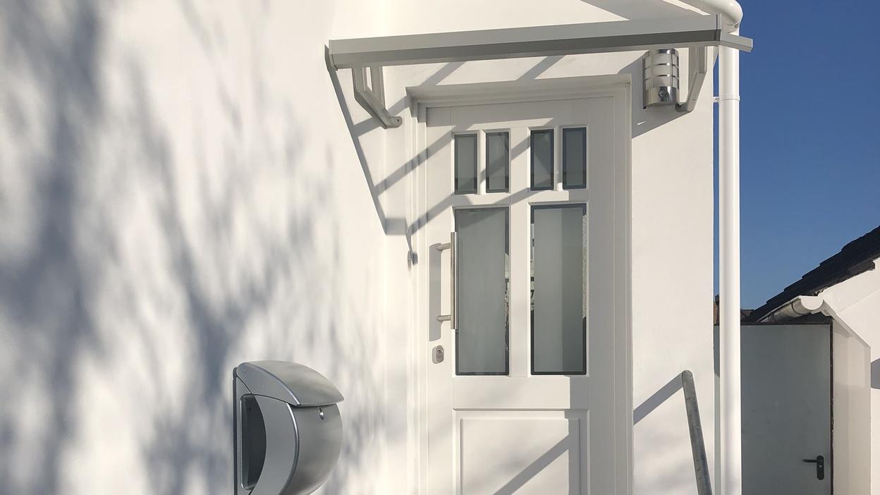 Hauseingang über Treppe mit weißer Haustür