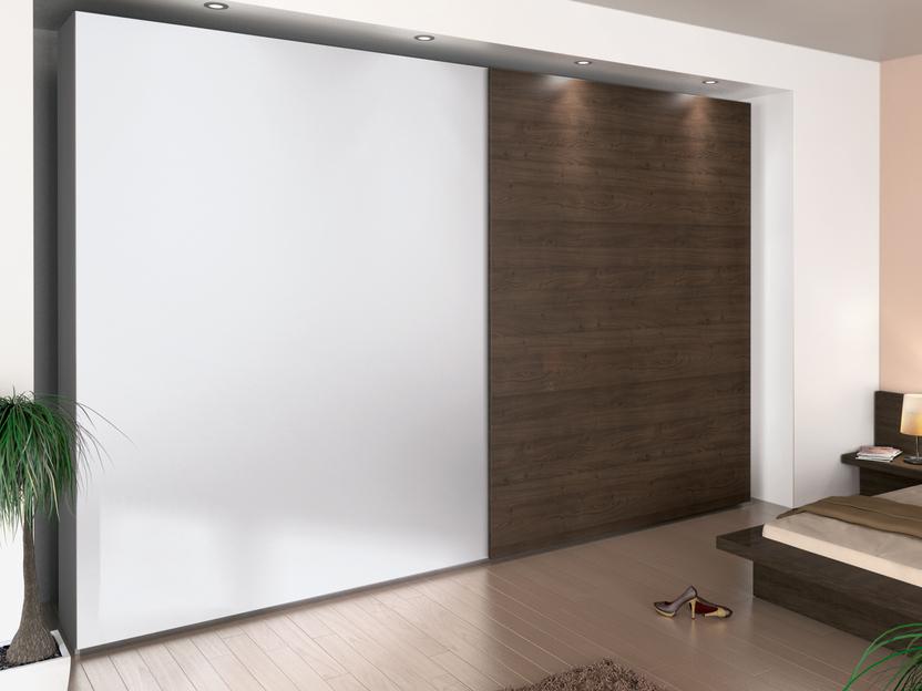 Schlafzimmerimpression mit Einbauschiebetürenschrank in weißer und dunkler Lackierung kombiniert.